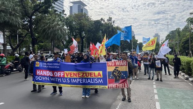 Massa buruh dan mahasiswa membawa spanduk saat aksi solidaritas untuk Venezuela di Jakarta