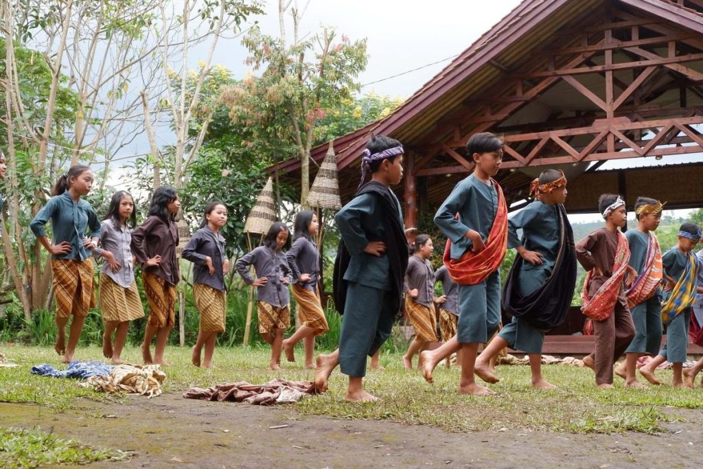 Suasana Desa Wisata Saung Ciburial di Garut dengan panorama alam, aktivitas budaya, dan tradisi Ngagogo khas masyarakat setempat.